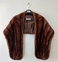 Full view of sable fur stole on hanger showing shape and color