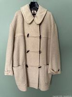 Front view of ivory wool duffle coat showing toggles, pockets, overall condition