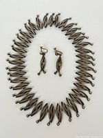 Choker necklace laid in oval with matching earrings inside