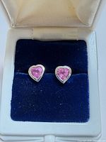 Front view of both heart-shaped pink sapphire earrings in box
