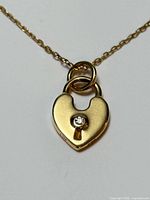 Front view of 18K gold necklace showing heart pendant with diamond