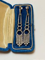 Pair of silver rhinestone clip-on earrings in blue velvet box, showing design, stones and box condition