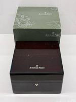 Closed wooden watch box with outer cardboard box visible