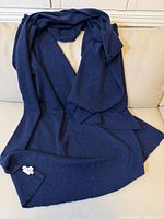 Full view of navy cashmere wrap laid on sofa