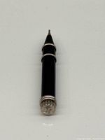 Full view of pin pusher showing ebony body and white gold end caps