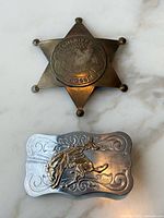 Badge and belt buckle front view highlighting design and materials