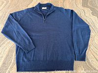 Front view of blue half-zip sweater laid flat