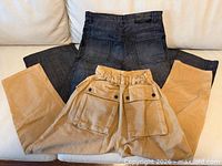 Both pairs of pants laid flat showing colors and styles