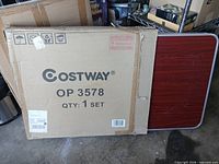 sealed Costway OP3578 carton with folded table leaning