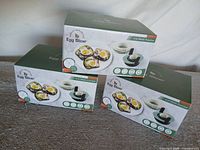 Front view of three boxed egg slicers showing product images and labels