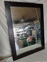 Front view of rectangular mirror showing dark wood-tone frame and reflective glass