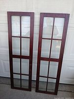 Two wooden window frames leaning against garage door