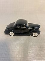 Left side profile of black 1940 diecast model car