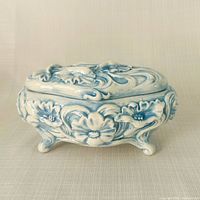 Front view of oval blue and white porcelain trinket box with lid on