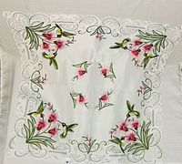 Full view of embroidered square tablecloth, showing hummingbird and flower motifs