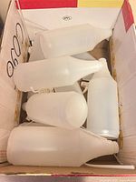 Box containing nine translucent plastic spray bottles