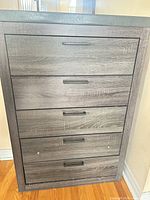 Full front view showing five drawers and grey wood finish