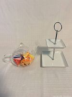 Glass teapot and two-tier tray side by side
