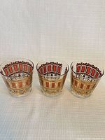 Three Culver Cranberry Scroll glasses front view showing gold and red design