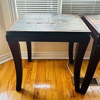 Side view of both matching dark wood tables showing slate tops and legs