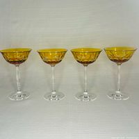 Front view of four amber cut crystal coupe glasses