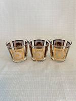 Front view of three matching tumblers showing gold and white panel design