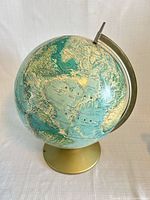 Full view of globe showing Atlantic Ocean side, brass-tone base and metal meridian arm
