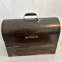 Closed black bentwood Singer carrying case showing exterior wear