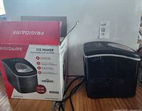 Ice maker unit beside original box showing model and specs