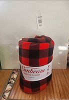 Rolled Sunbeam plaid heated throw with label visible
