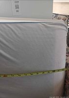Front of pillow with tape showing width about 27 inches