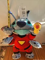 Front view of Stitch plush with measuring tape for height reference