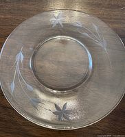 Single clear glass plate showing etched cornflower design