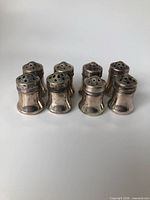 All eight silver-plated shakers grouped