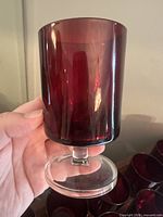 Close-up of single ruby red glass showing clear foot