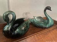 Both Blue Mountain Pottery swan bowls on wood surface