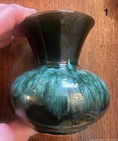Flared-neck bud vase showing glossy teal-green glaze and Blue Mountain Pottery foil label