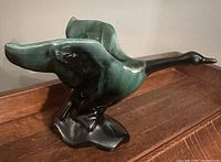 Left side view of Blue Mountain Pottery Canada goose figurine showing teal-to-black glaze and wing detail