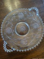 Top view showing entire round platter, bead rim, dual handles, etched Cornflower pattern