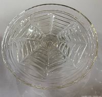 top view of clear pressed glass cake stand showing leaf and star pattern