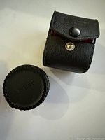 Leatherette case and plastic cap side by side