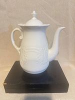 full view of Coalport white relief coffee pot front