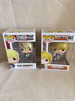 Front view of both boxed Funko Pop figures showing characters and figure numbers