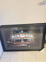 Full view of framed Helen Flint print leaning against wall