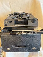 Front view of Kodak Carousel 4600 projector on top of carrying case with manual visible