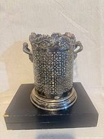 Front view pierced silver-plated cachepot on display stand