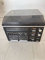 Front view of Sanyo GXT 212 showing tuner, equalizer, dual cassette decks, control buttons and dust-covered turntable