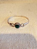 Full view of hinged sterling silver bangle showing malachite center and clasp