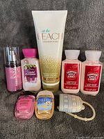 All eight Bath & Body Works items arranged together: body cream, four travel lotions, fragrance mist, two PocketBac sanitizers, silicone holder