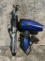 Conair metallic blue hair dryer and chrome curling iron, cords wrapped
